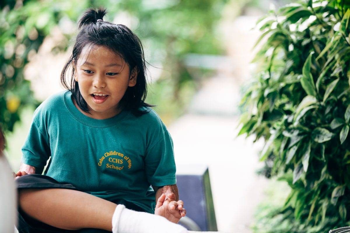 Young girl wearing a teal shirt.