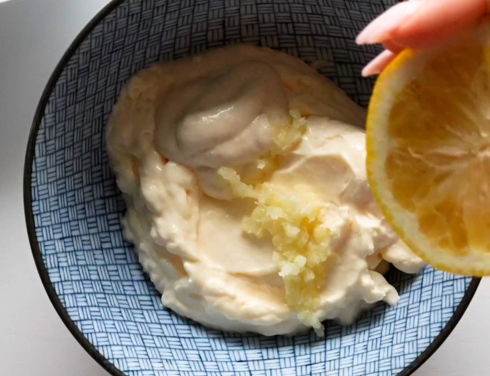 Making garlic aioli in a bowl.