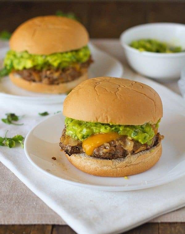 Southwest chipotle burgers with guacamole on plates.