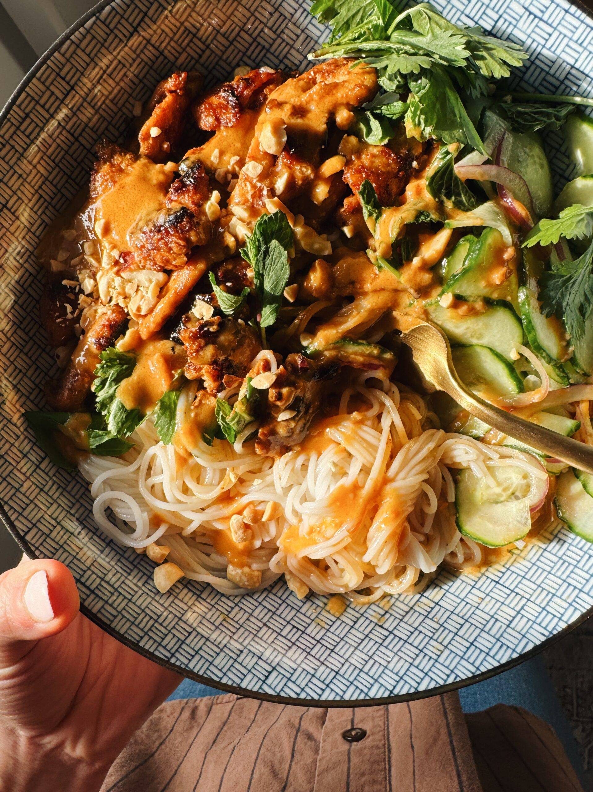 Peanut chicken with noodles and cucumber.