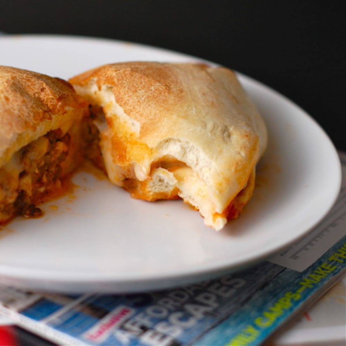 Sausage and mozzarella calzones on a white plate.