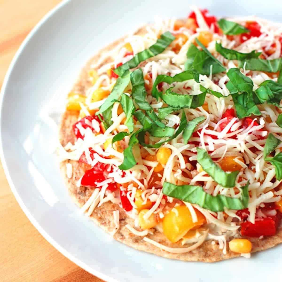 Mozzarella, Basil, and Corn Quesadilla on a white plate.